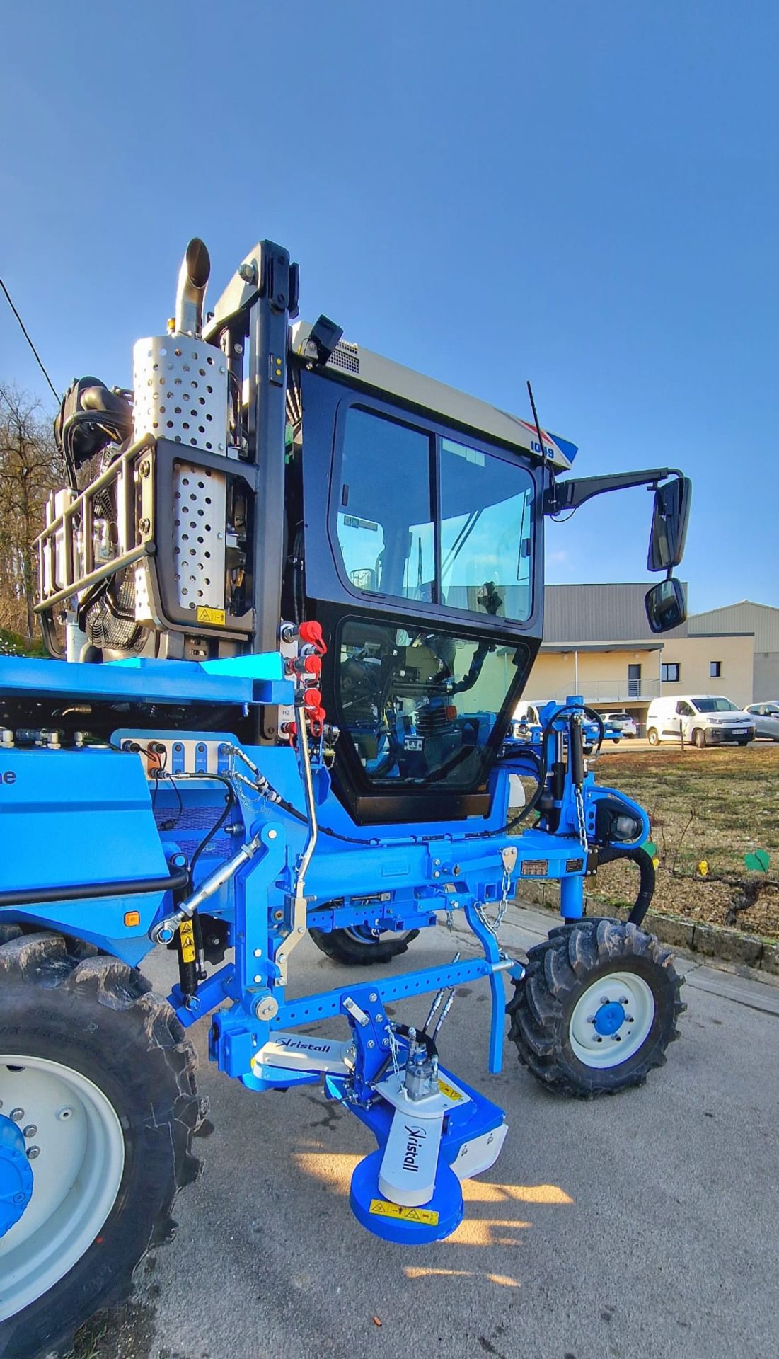Tondeuse Calissto de Kristall Agri montée sur un enjambeur, vue de côté.